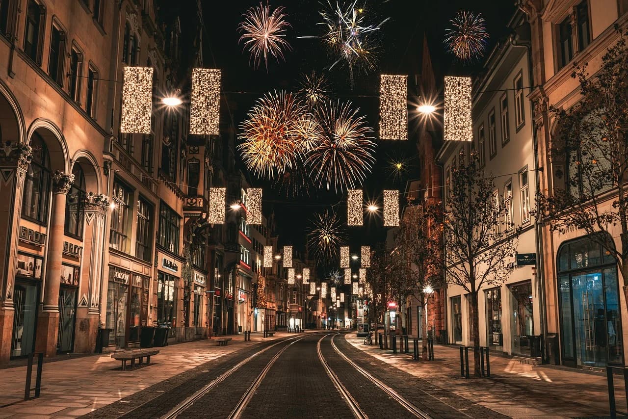 The streets of Erfurt are beautifully decorated with illuminated lights and fireworks, creating a festive atmosphere at night.