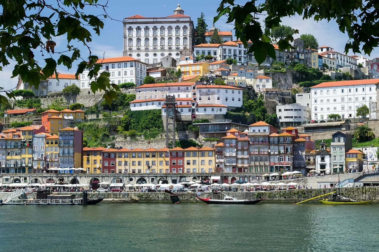 A scenic view of the colorful houses of the Ribeira district, a UNESCO World Heritage site, built on a hillside overlooking the Douro River.