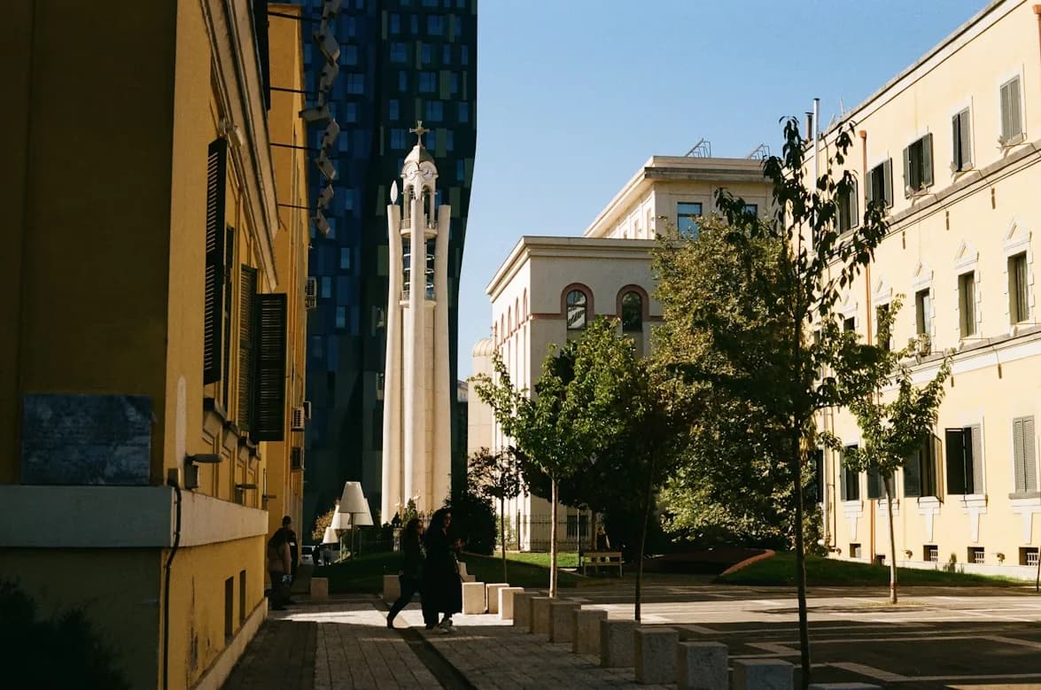 The Palace of Culture, a neoclassical building, stands in a city square in Tirana.