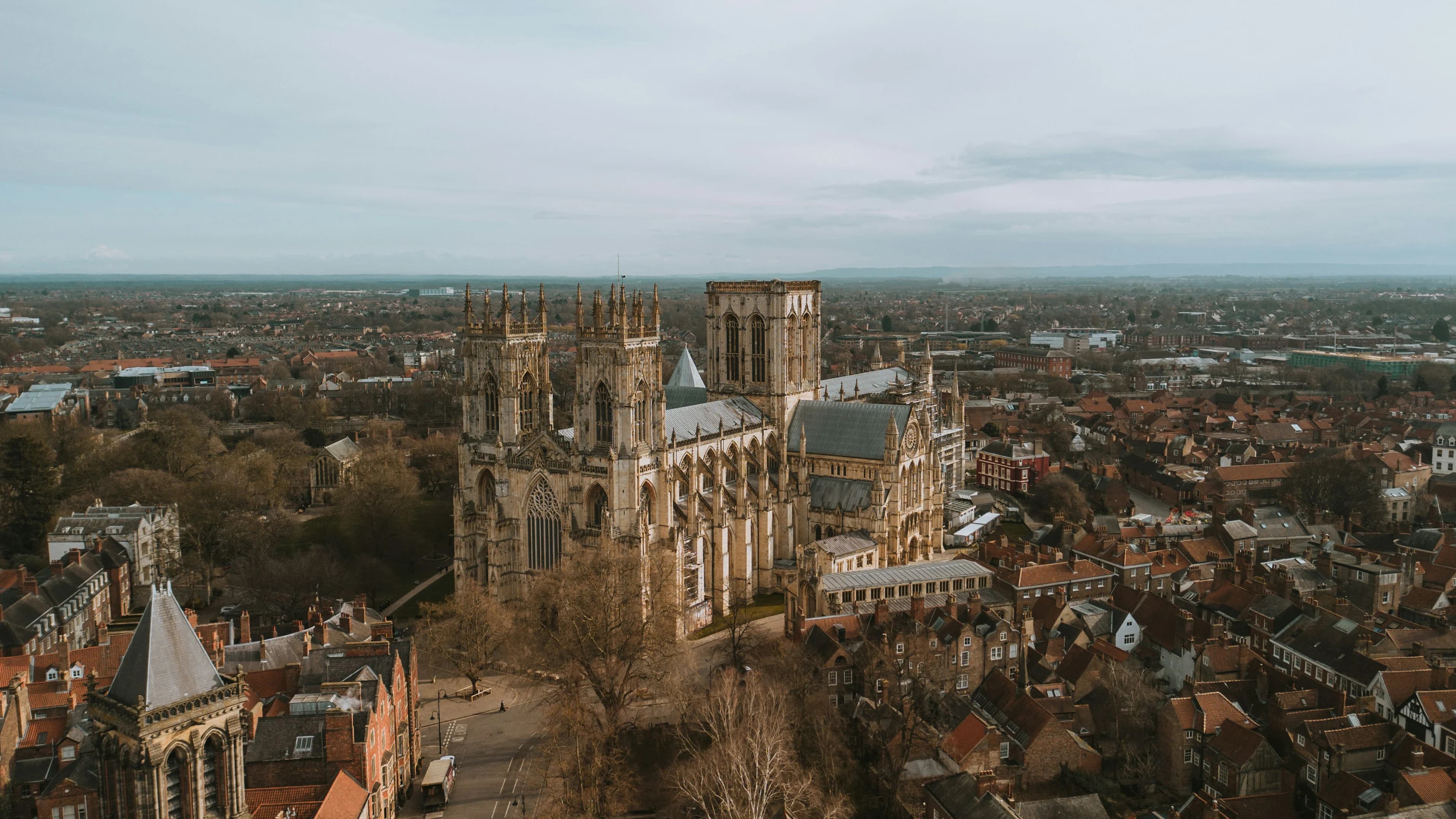 An aerial view captures the immense and intricate gothic structure of York Minster surrounded by the city’s residential rooftops.