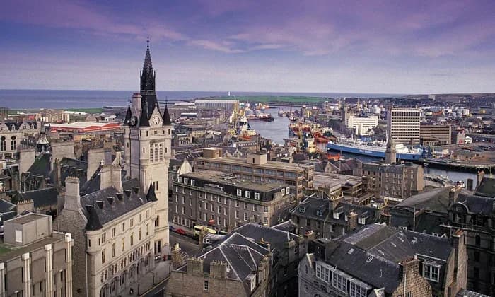 A panoramic view of Aberdeen's cityscape, with a mix of historic buildings and the bustling harbor in the distance.