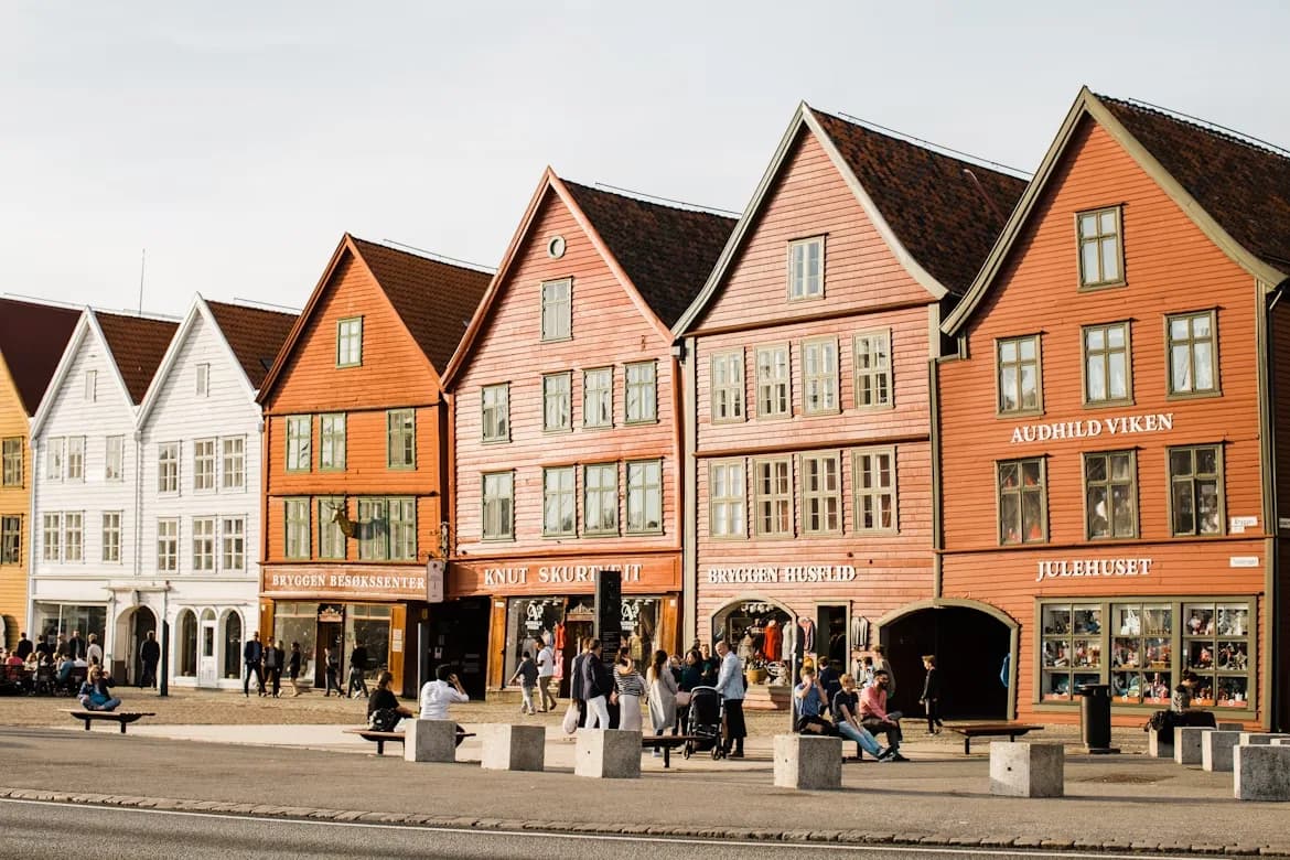 People stroll along the waterfront of Bryggen, admiring the row of historic wooden buildings with their unique facades.