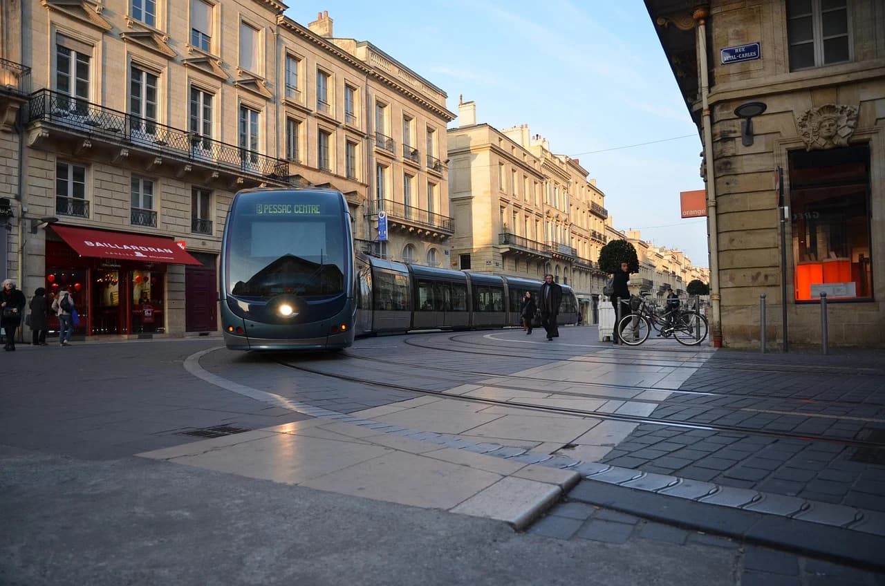 A modern tram glides through the cobblestone streets of Bordeaux, showcasing the city's blend of old and new.