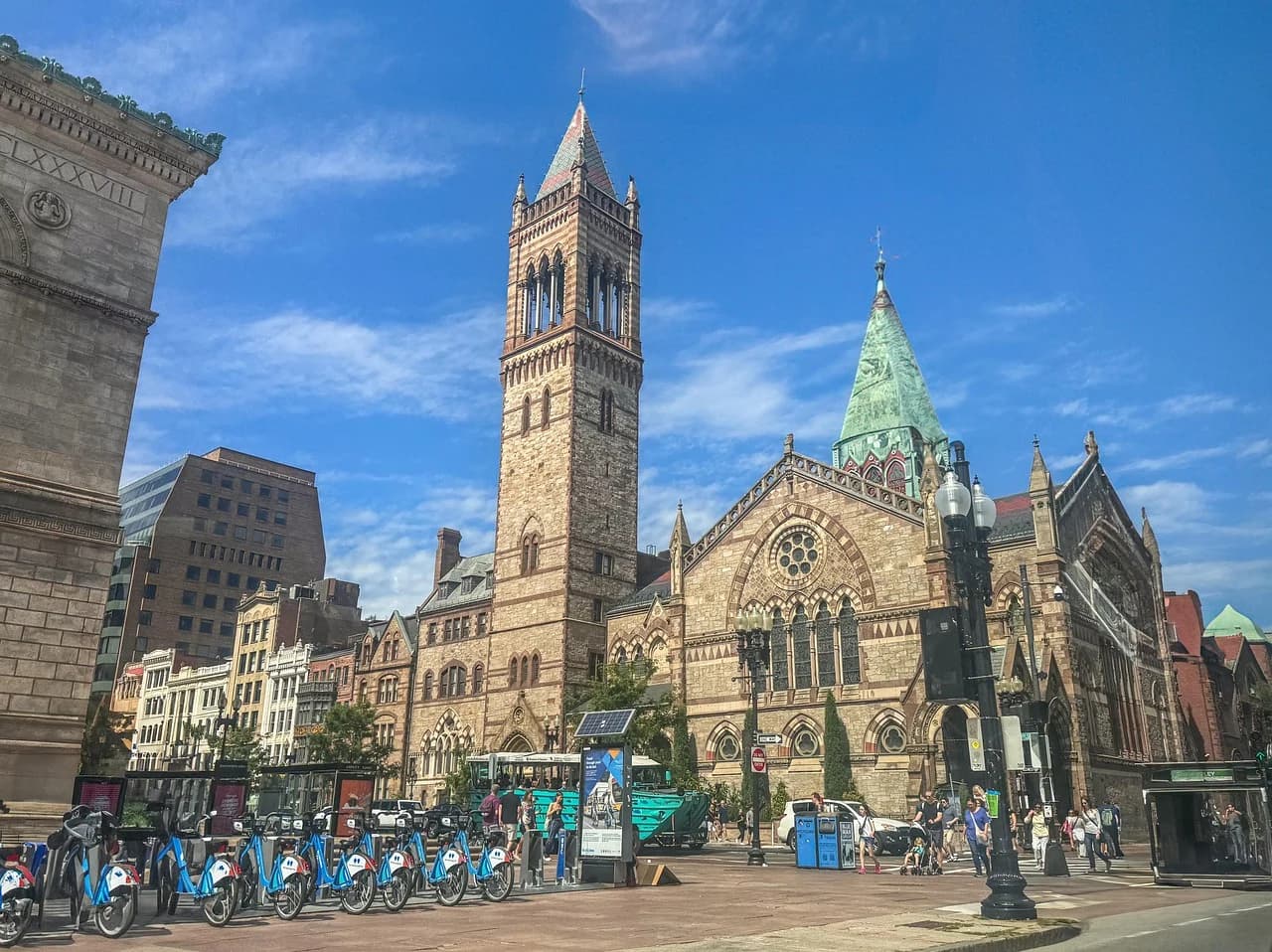 The magnificent Old South Church, with its soaring bell tower, is a prominent landmark on a busy city street with bicycles in the foreground.