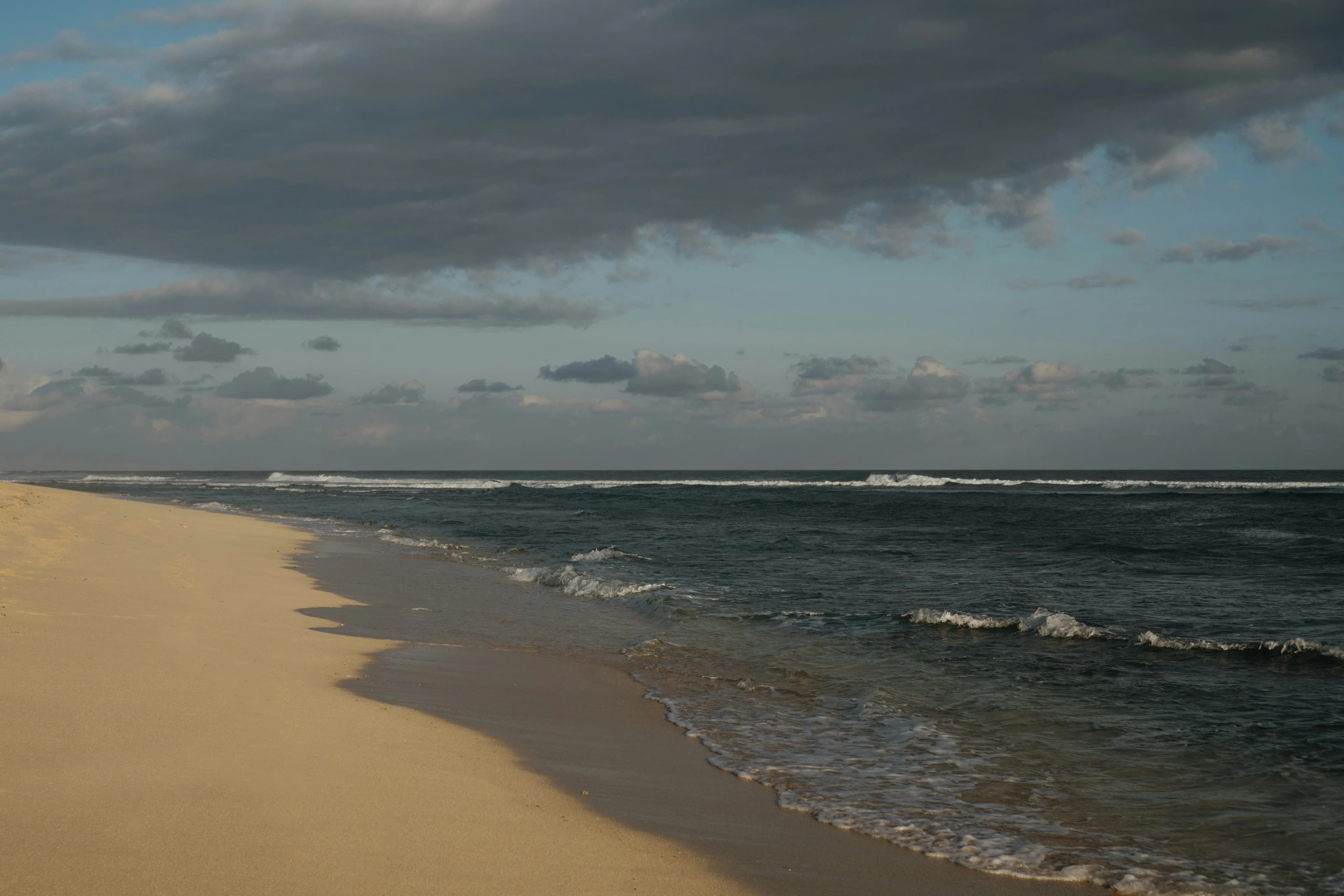 The peaceful, sandy beach of Cape Verde is bordered by gentle waves and the vast, blue ocean.