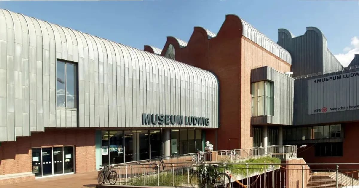 The Museum Ludwig, a modern art museum with a unique metal roof, stands in a bustling part of the city.
