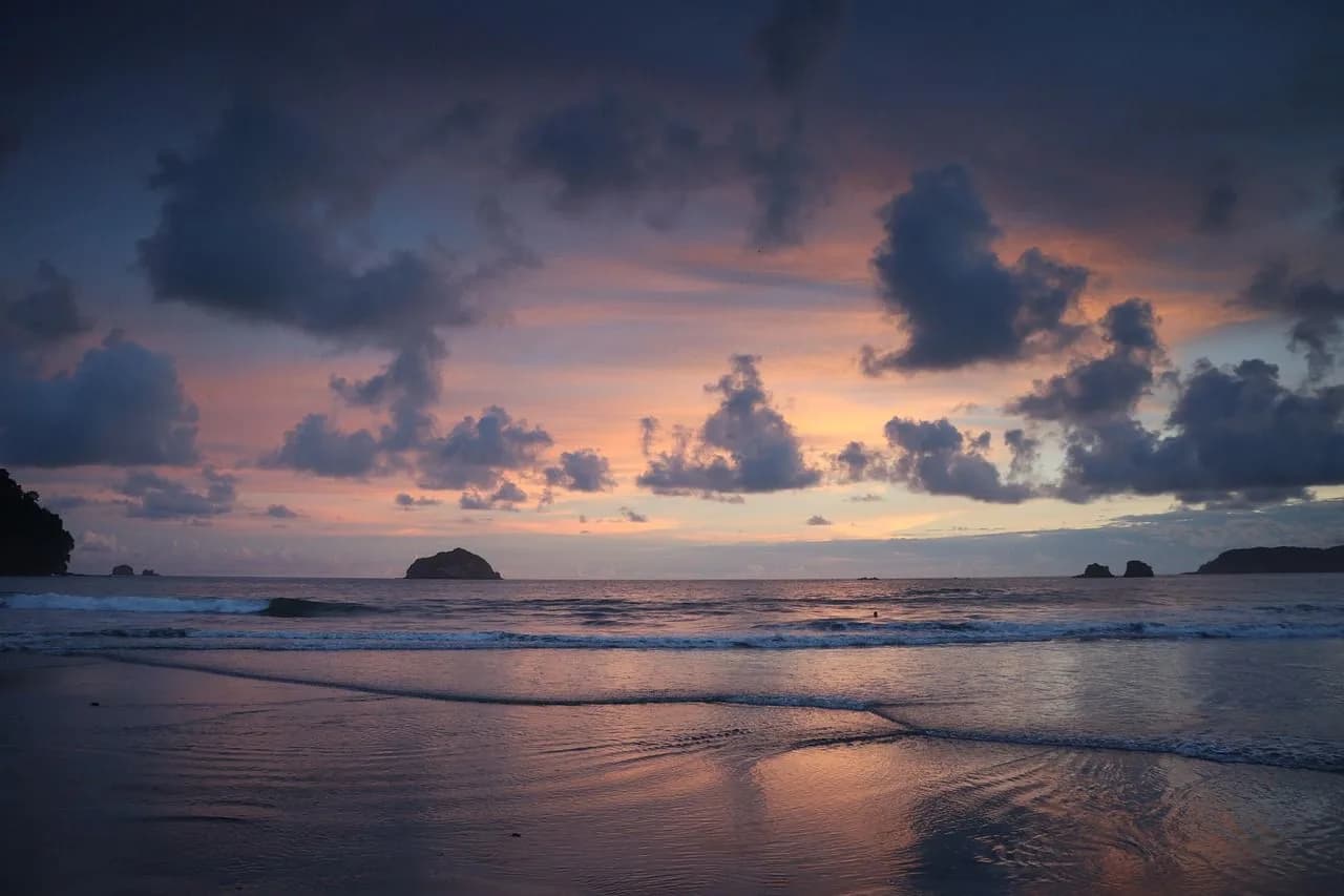 A panoramic view of the rugged coastline shows the turquoise water of the sea meeting the golden cliffs.