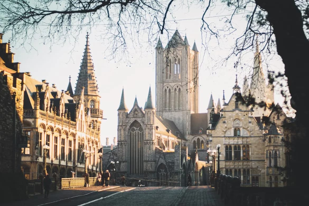 The soaring spires of St. Nicholas' Church and the Belfry of Ghent are the heart of the city, framed by ancient cobblestone streets and buildings.