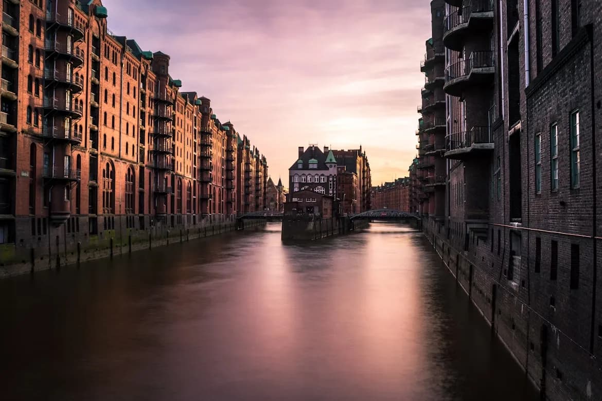 The Speicherstadt, Hamburg's historic warehouse district, is beautifully reflected in the canals at sunset.