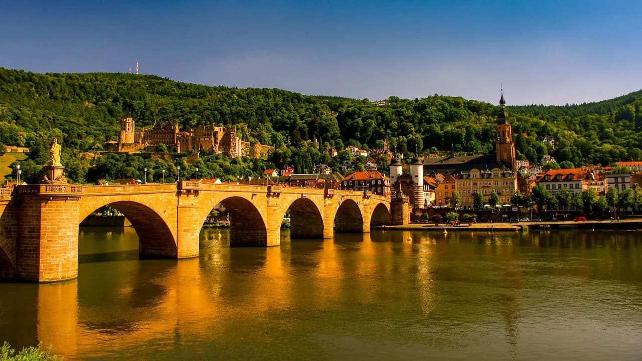 The Old Bridge, or Alte Brücke, with its elegant arches, spans the Neckar River, providing a stunning view of Heidelberg Castle and the historic Old Town.