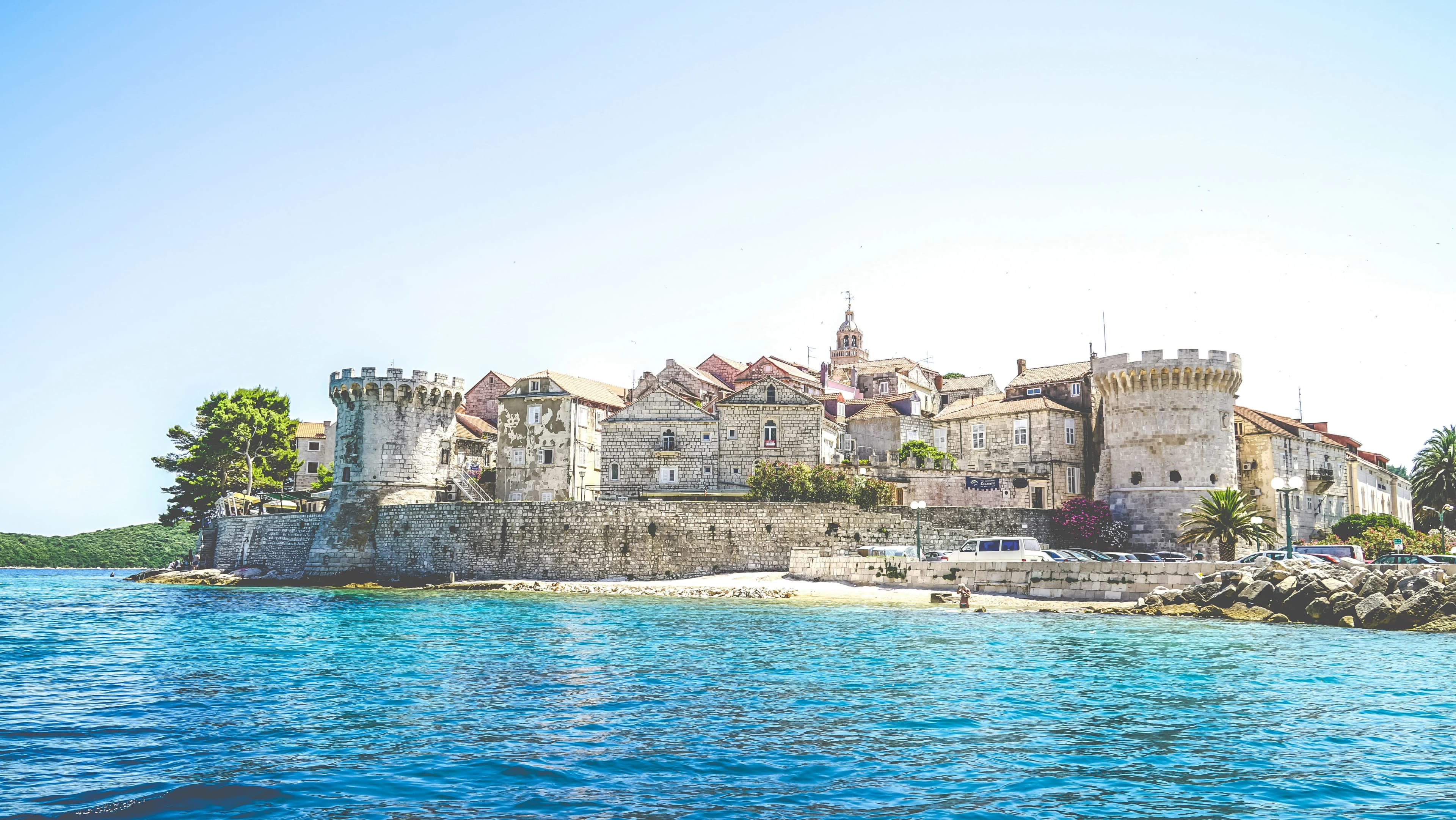 The medieval bell tower of the Korčula Cathedral, a masterpiece of Venetian architecture, rises above the city's red rooftops.