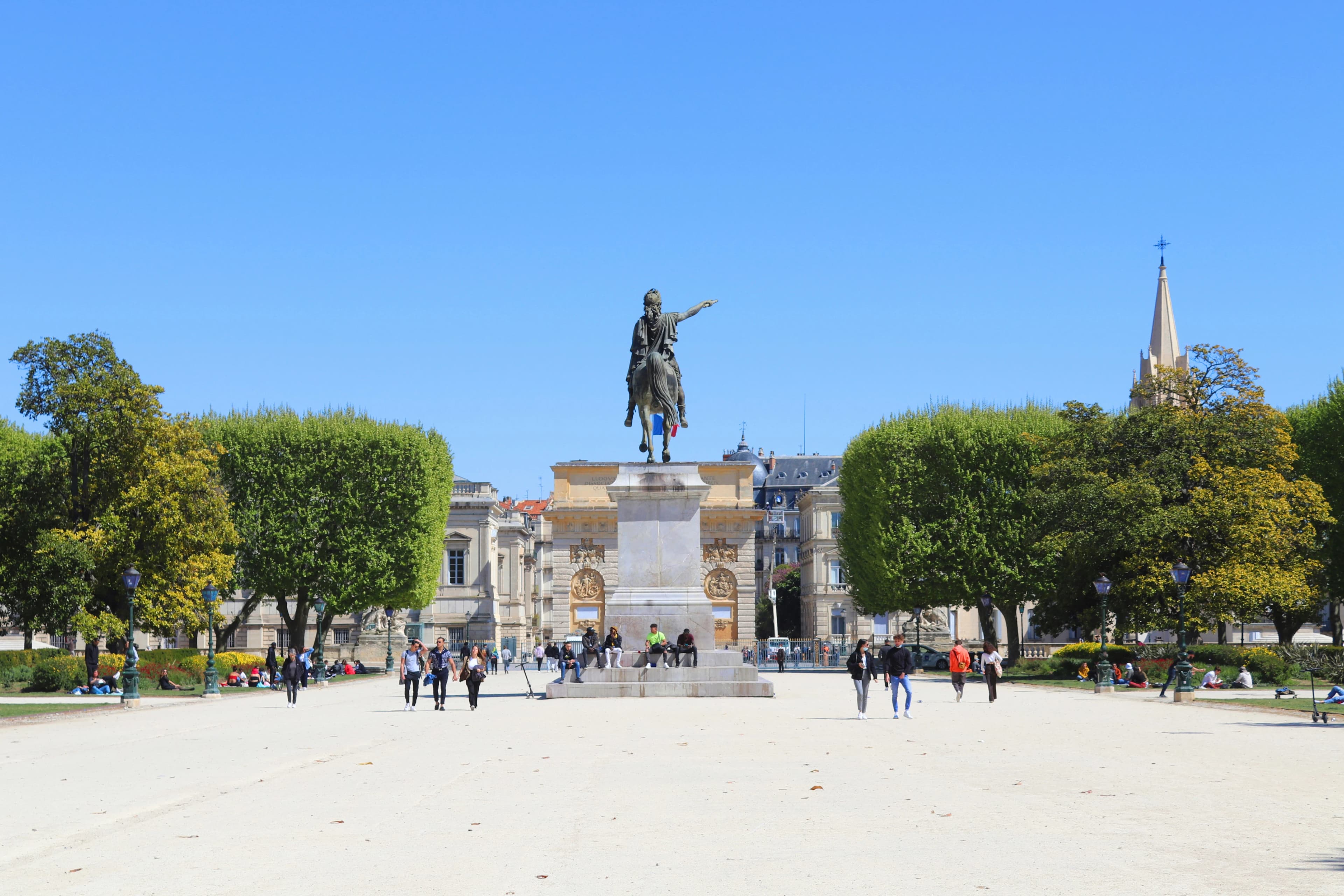 The beautiful Place du Peyrou, with its large equestrian statue of Louis XIV, is a grand public square surrounded by green trees.
