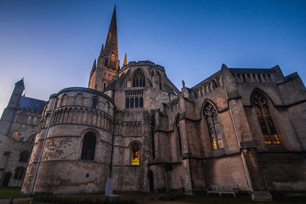 The soaring spire and intricate gothic architecture of Norwich Cathedral are a stunning sight at dusk.