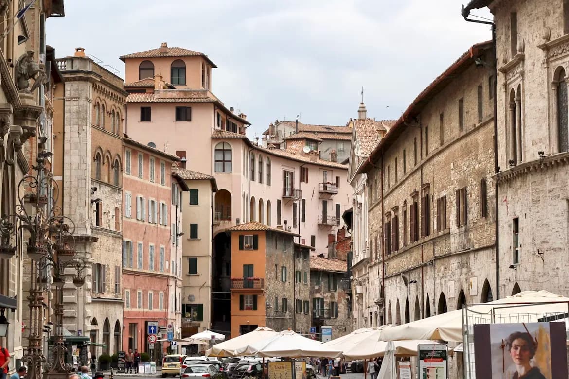 A cobblestone street in Perugia is lined with elegant, historic buildings and busy cafes.