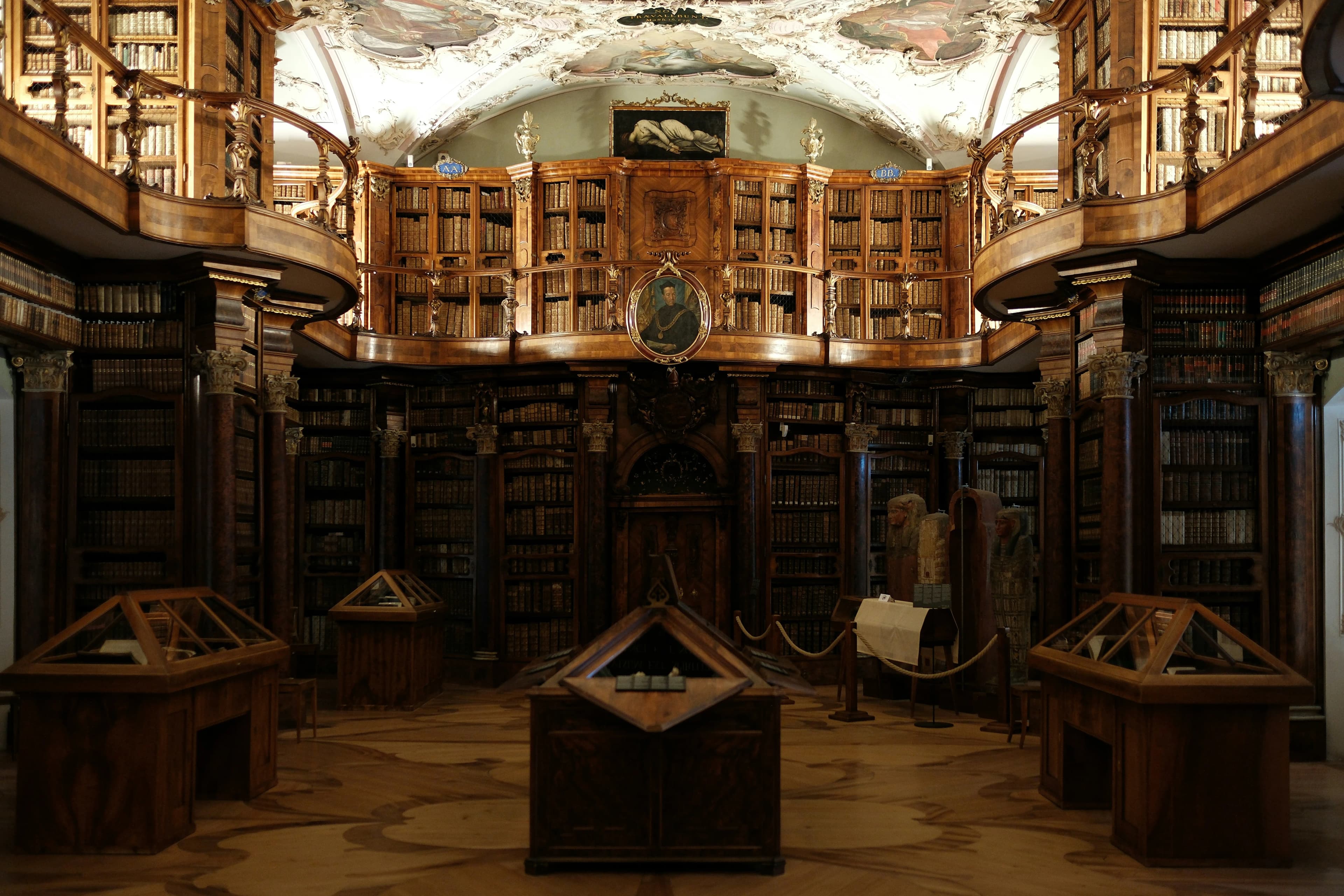The grand, majestic interior of the Abbey Library of St. Gall, with its ornate wooden shelves and high, vaulted ceiling.