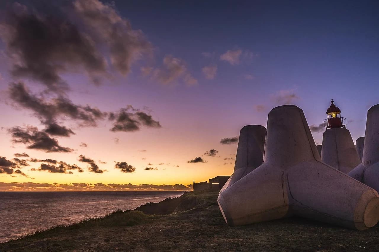 The beautiful and unique volcanic landscape of the Azores is a stunning sight, with a lake and a few small islands in the distance.