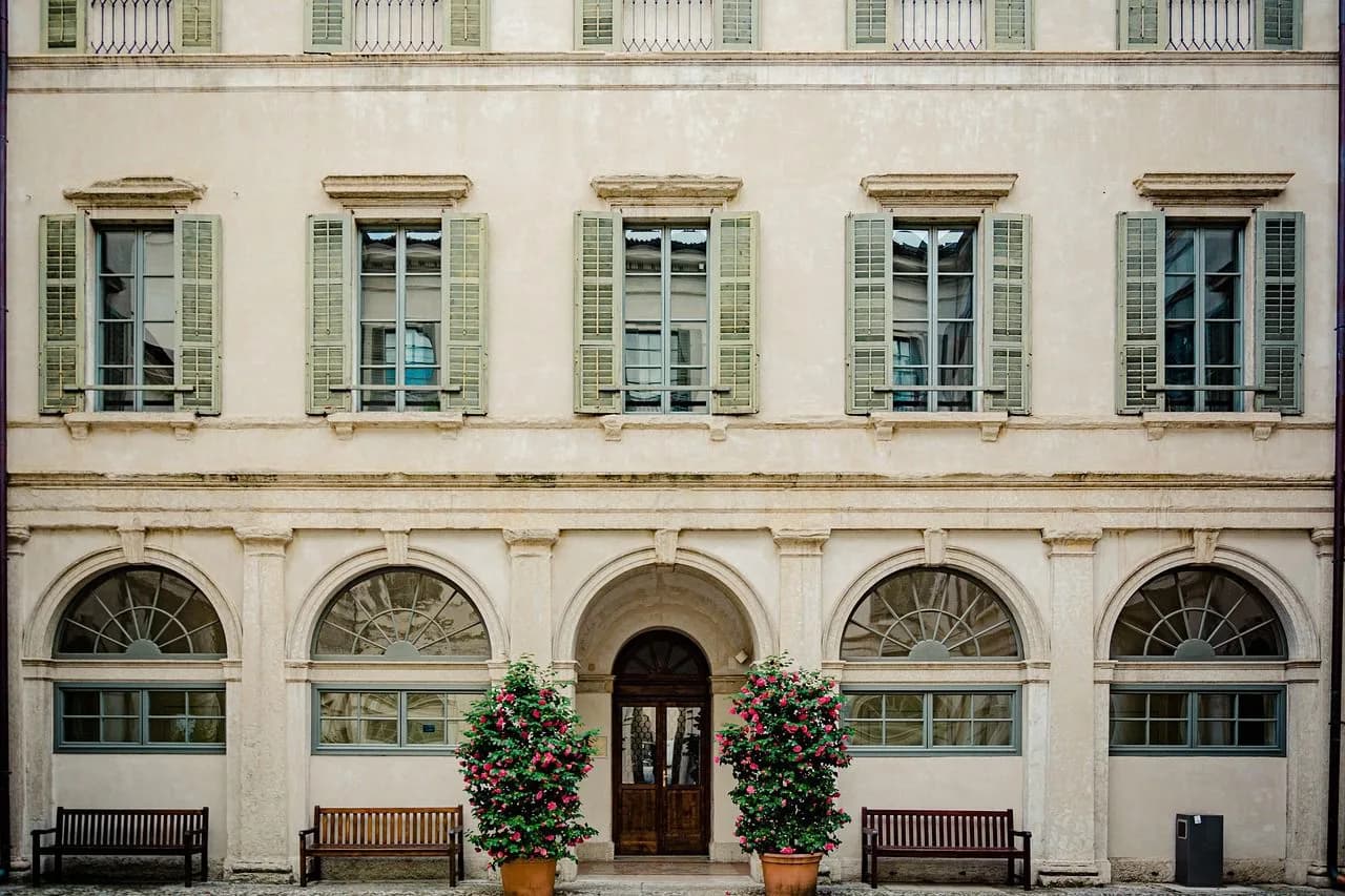 A scenic road winds through the green mountains of the Trento countryside.