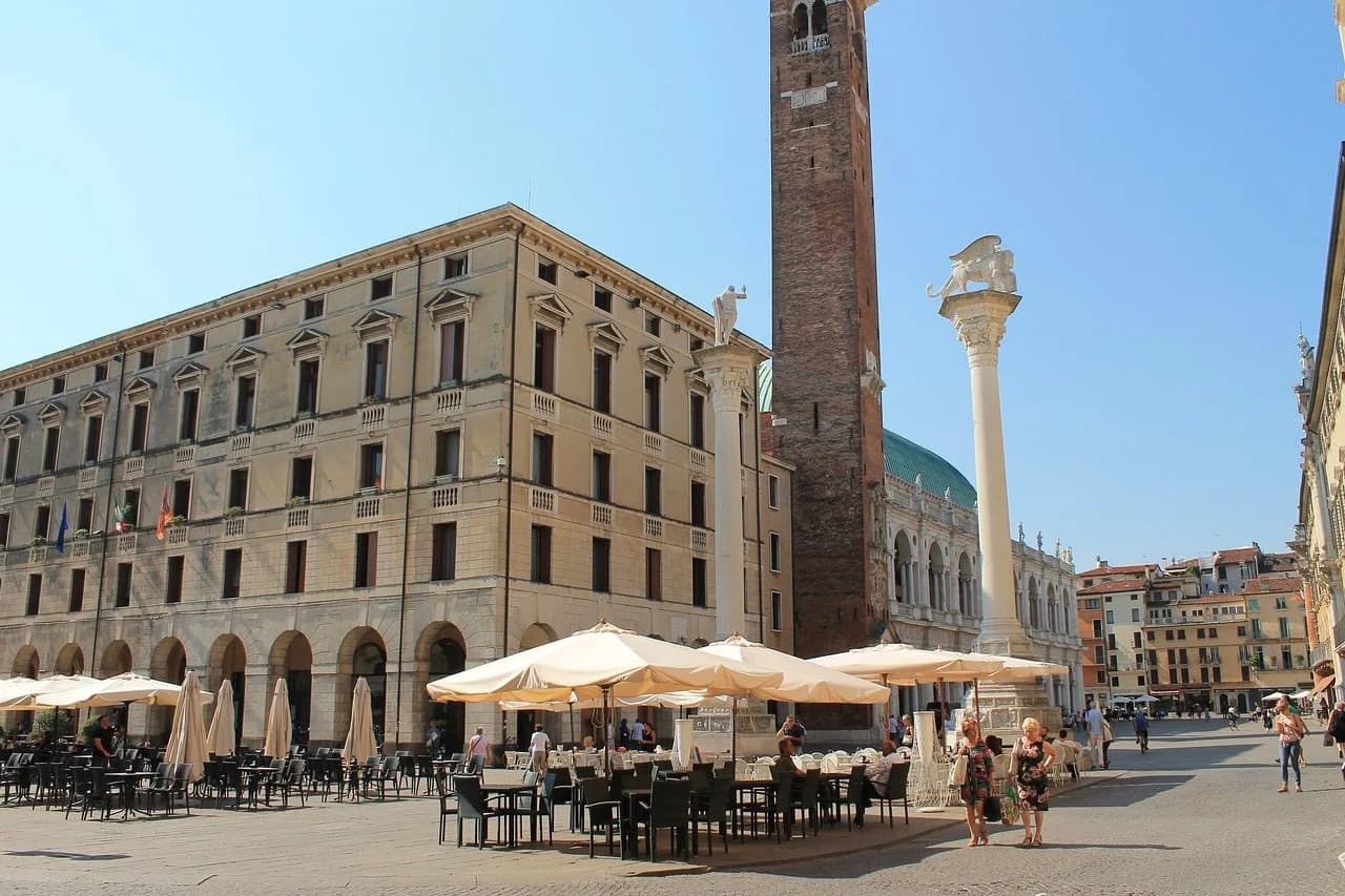 People gather in the Piazza dei Signori, Vicenza's main square, with the Basilica Palladiana and a statue on a tall column.