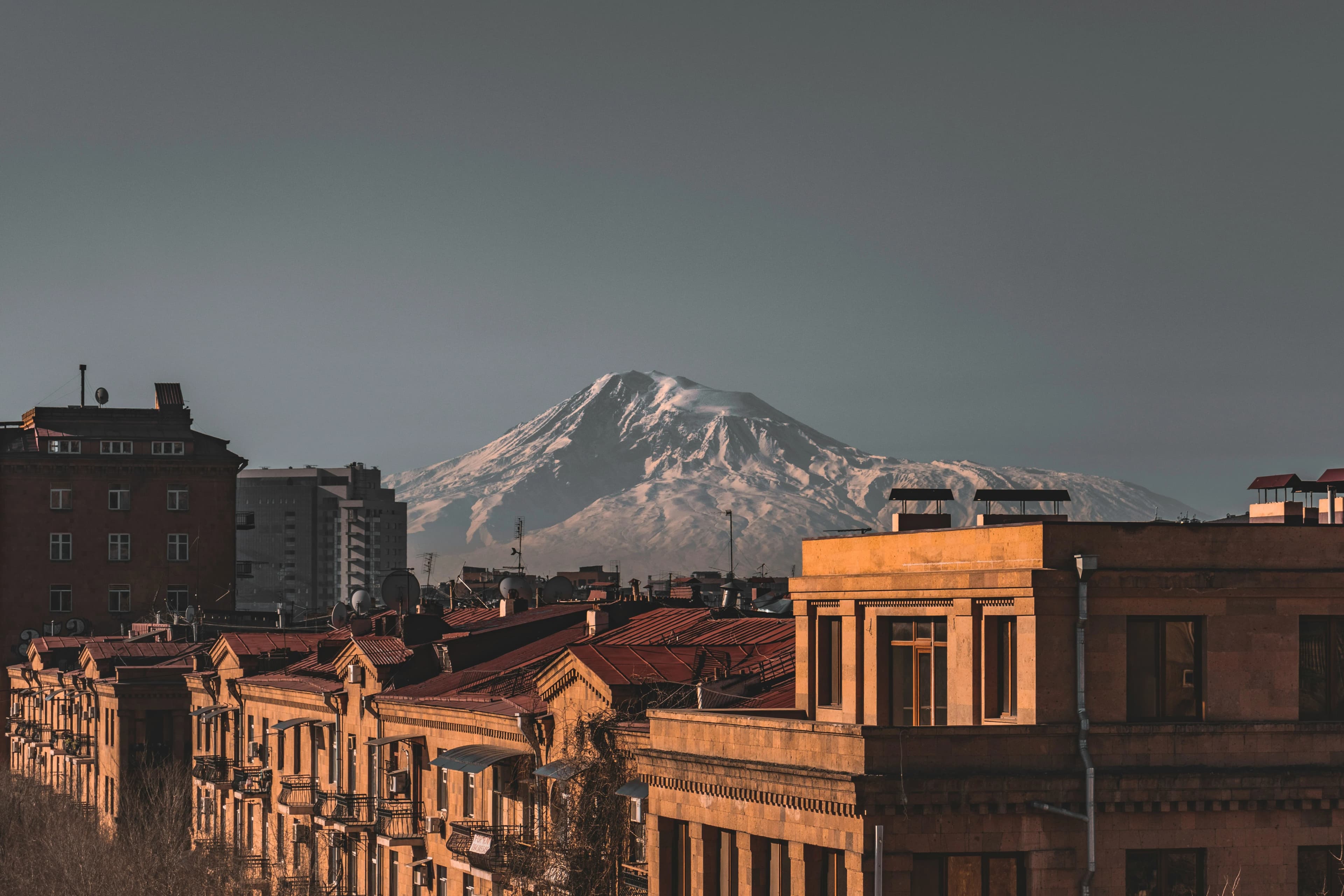 A street view of Yerevan with a clear shot of Mount Ararat rising above the city's rooftops.