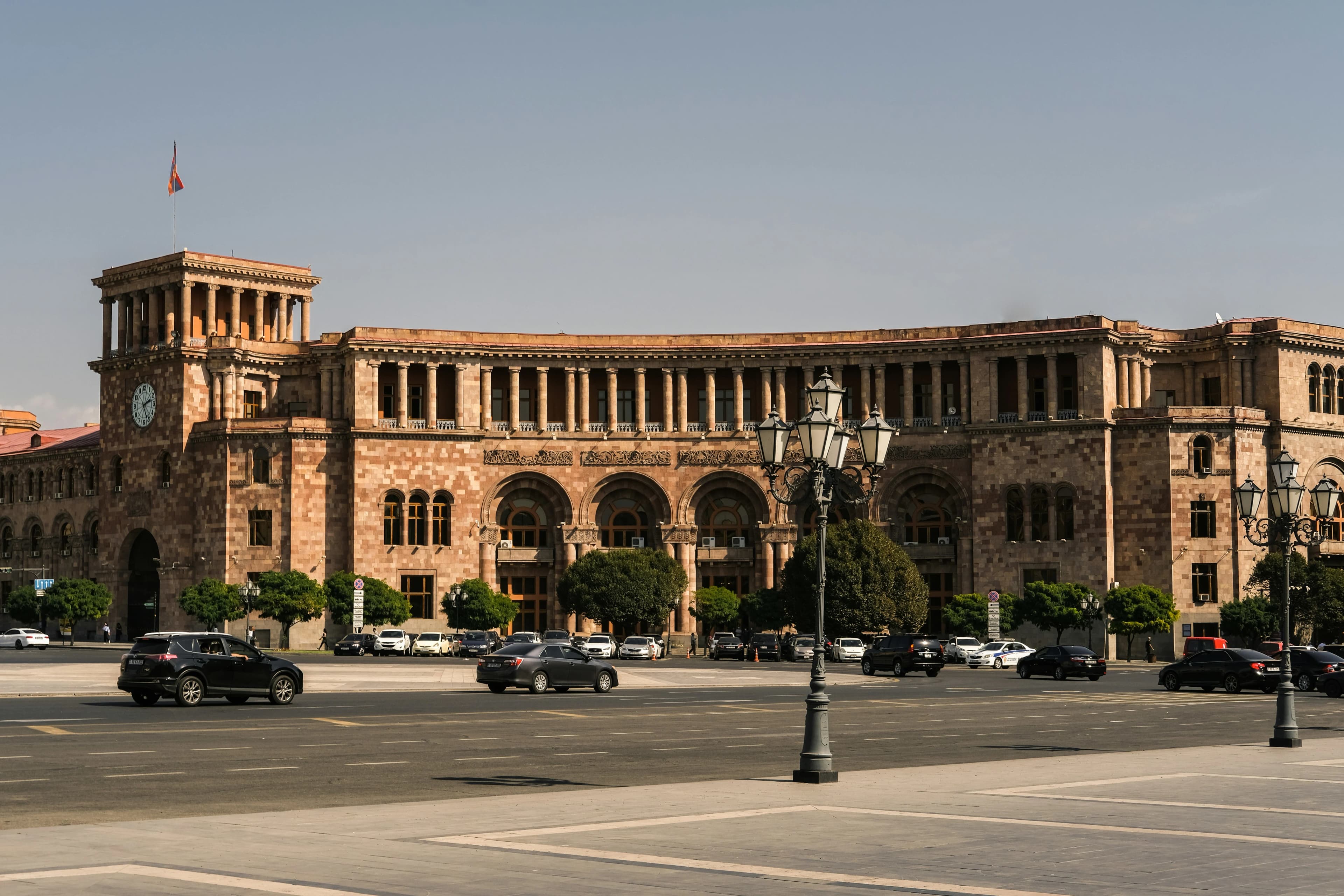 The historic Republic Square in Yerevan, featuring a large, ornate government building with a clock tower and a fountain at its center.
